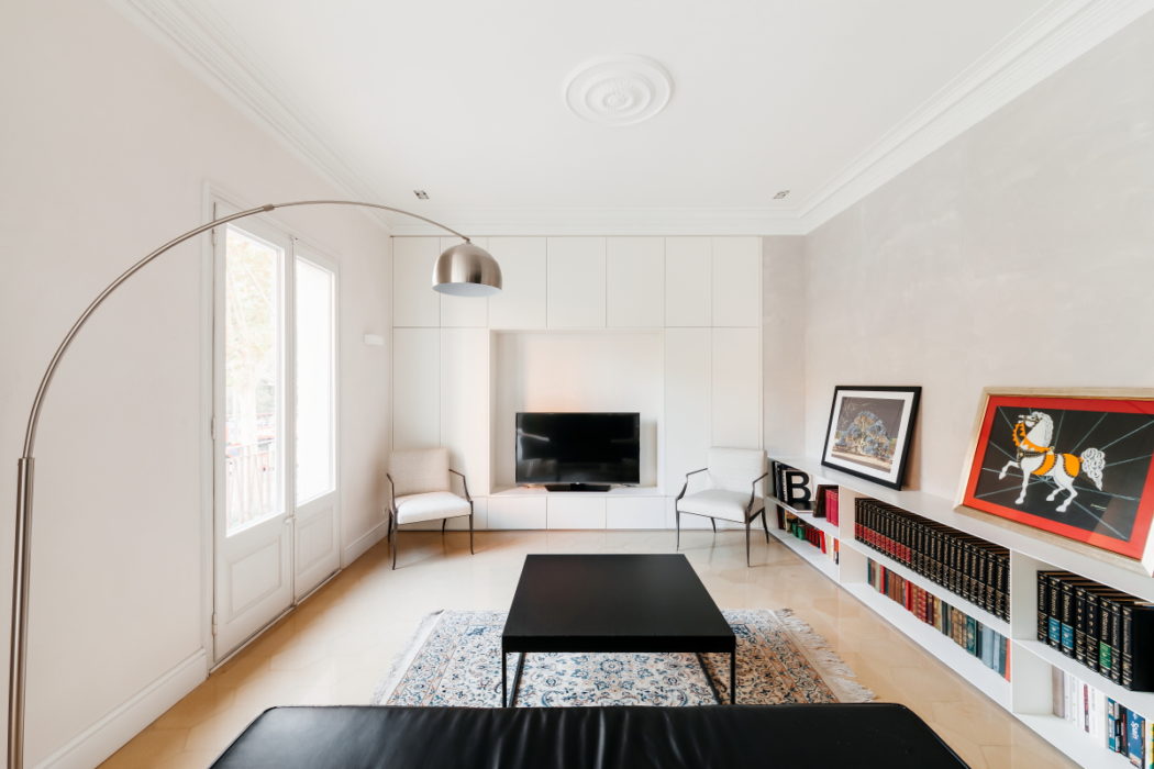 Elegant living room with sleek furnishings and ornate ceiling.