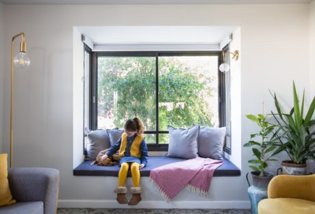 Cozy window seat with cushions and a mixed color scheme.