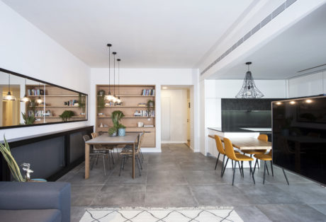 Modern kitchen and dining area with minimalist furniture and pendant lighting.