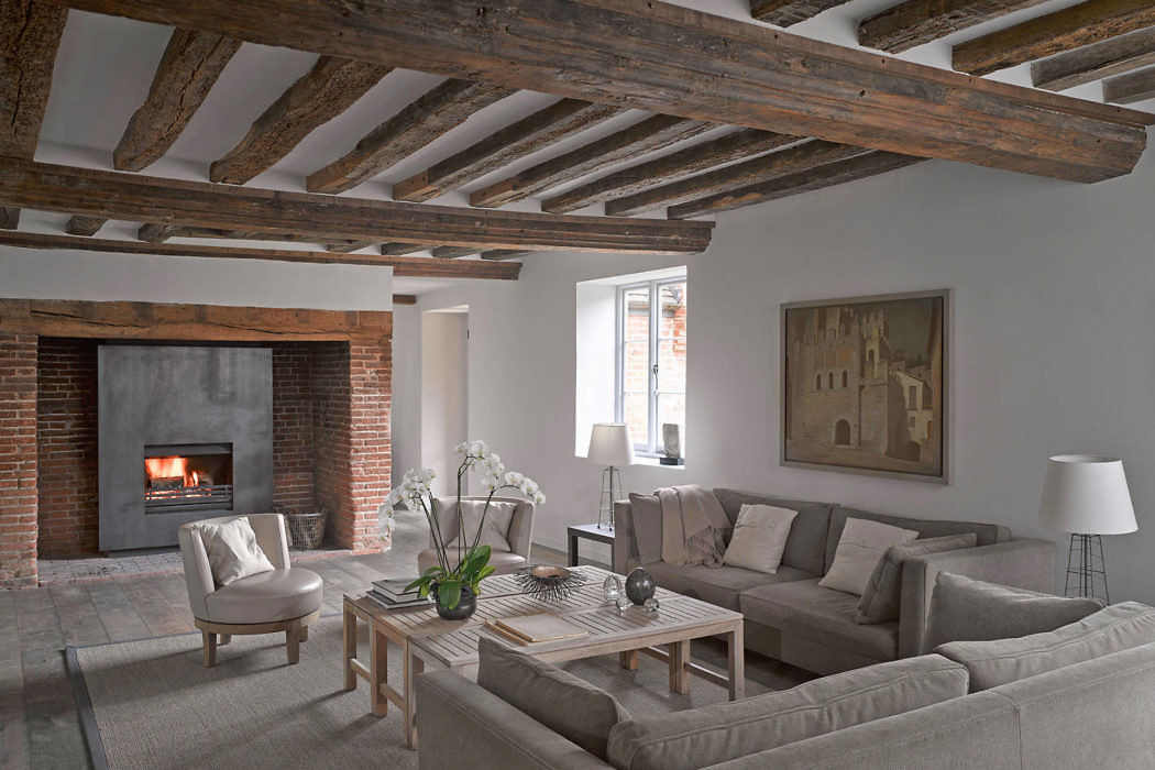Contemporary living room with exposed beams and brick fireplace.