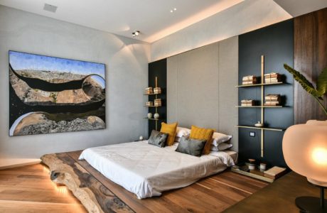 Stylish bedroom with wooden elements and large artwork.