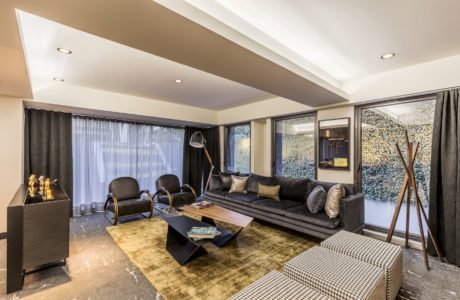 Contemporary living room with sleek furniture and textured accent wall.