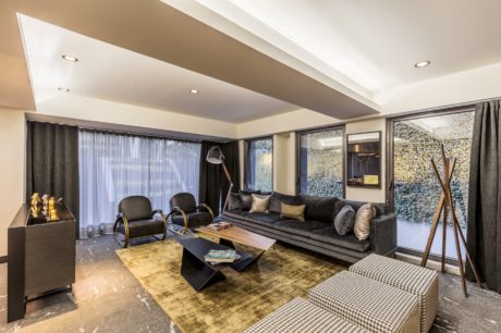 Contemporary living room with sleek furniture and textured accent wall.