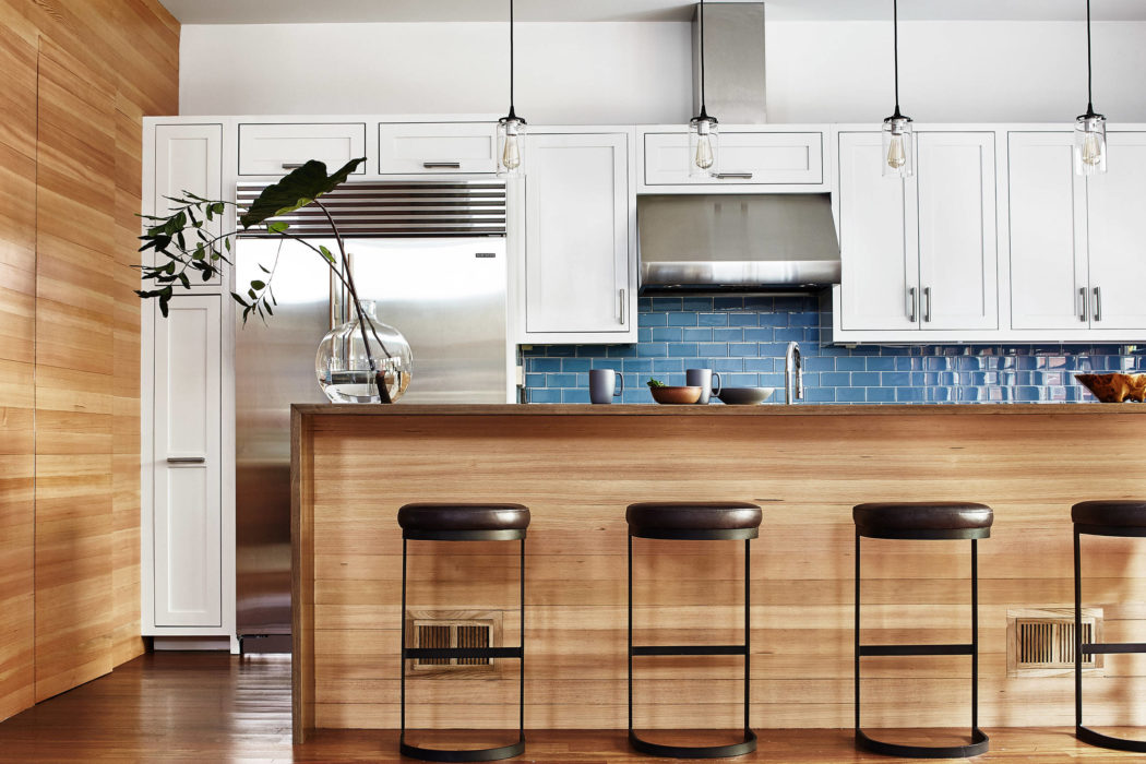 Contemporary kitchen with blue tile backsplash and wooden accents.