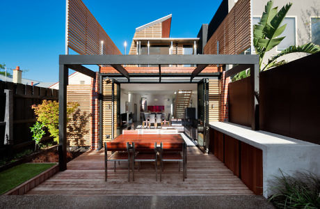 Contemporary outdoor dining area with wooden decking and sleek furniture.