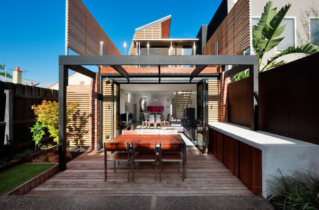 Contemporary outdoor dining area with wooden decking and sleek furniture.