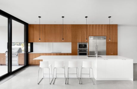 Sleek kitchen interior with wooden cabinets and a white island.