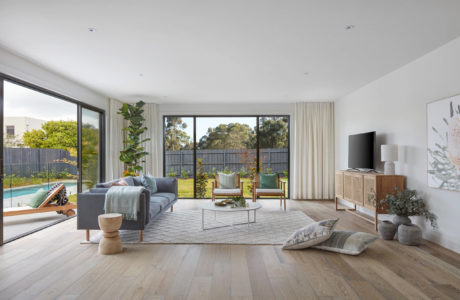 Modern living room with large window overlooking a pool.