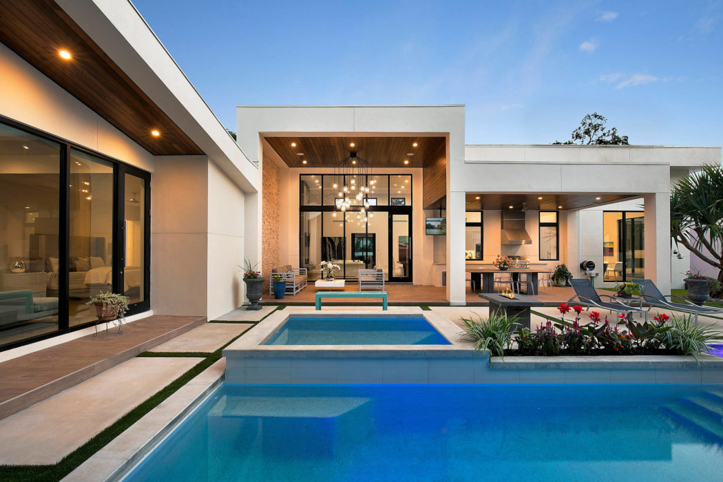 Contemporary house with pool and glass doors at dusk.