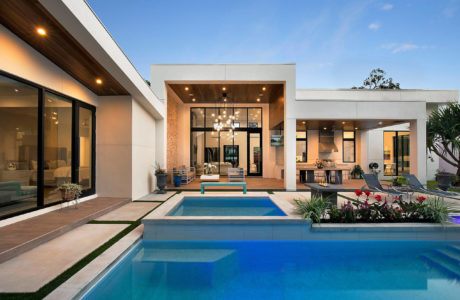 Contemporary house with pool and glass doors at dusk.