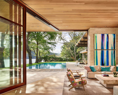 Sleek lakeside living space with expansive windows and pool.