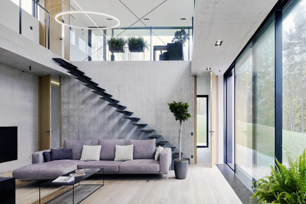 Sleek interior with floating staircase and floor-to-ceiling windows.