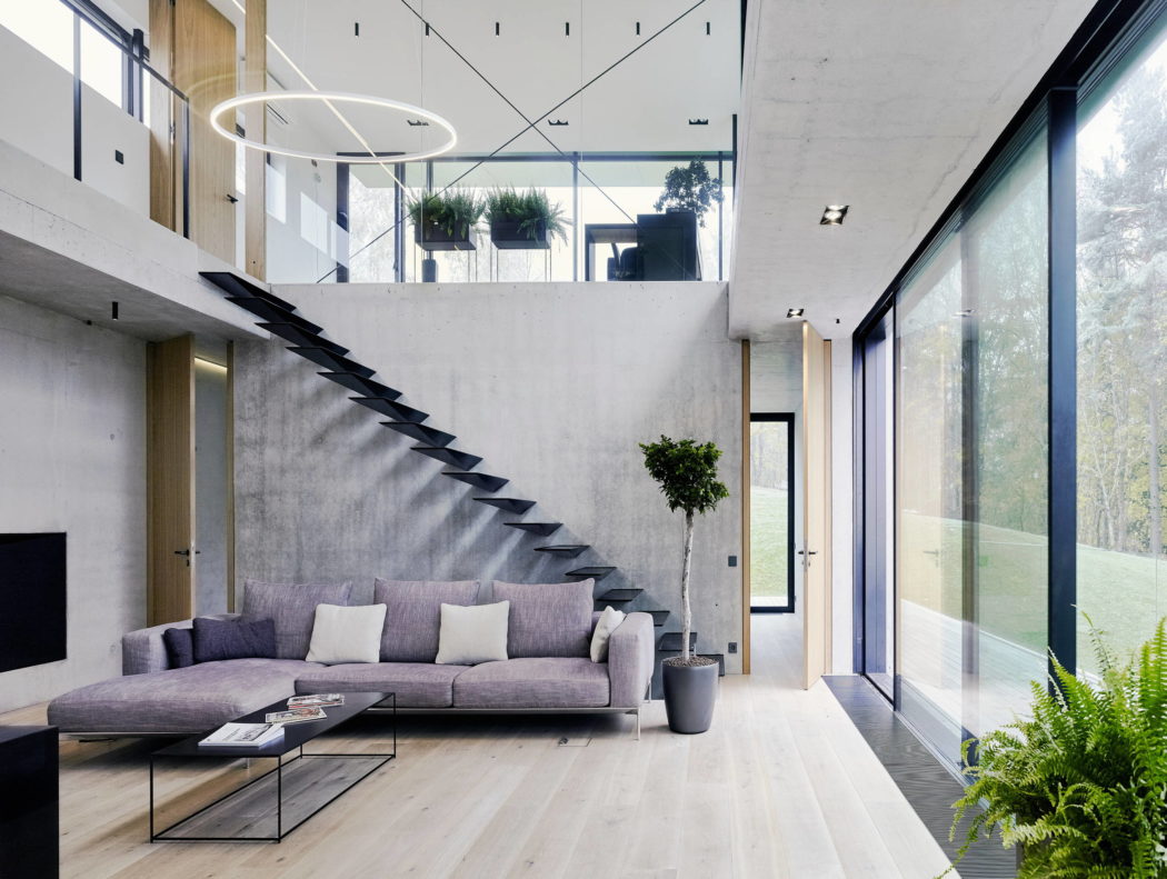 Sleek interior with floating staircase and floor-to-ceiling windows.