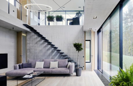 Sleek interior with floating staircase and floor-to-ceiling windows.