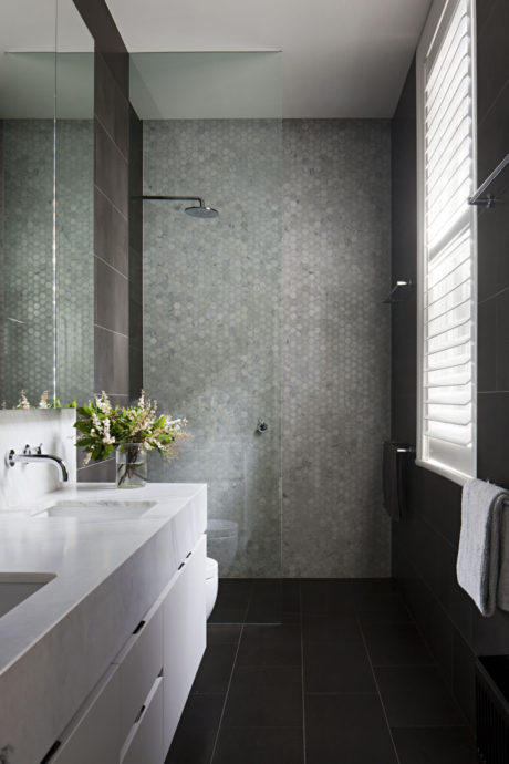 Contemporary bathroom with mosaic tiles and dark floor.