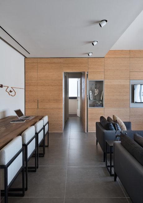 Contemporary living room with wooden paneling and sleek furniture.