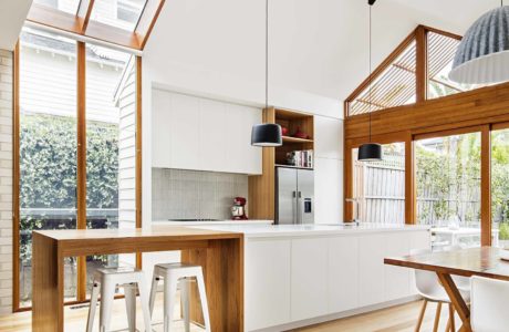 Modern kitchen with high ceilings, skylights, and a mix of white and