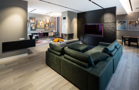 Modern living room with sectional sofa and wall-mounted TV.