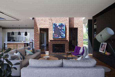 Modern living room with brick fireplace and L-shaped sofa.