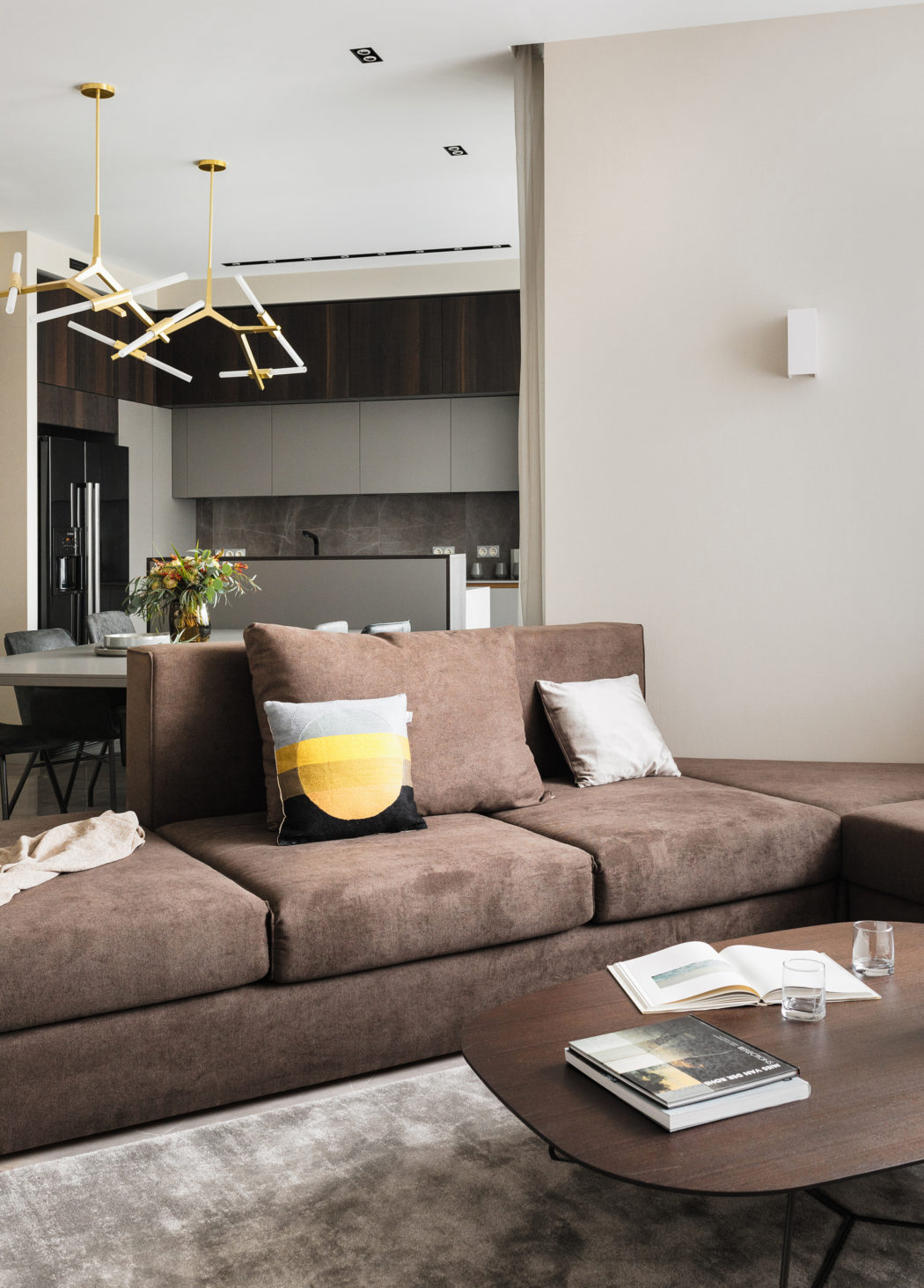 Contemporary living room with brown sectional sofa and geometric light fixture.