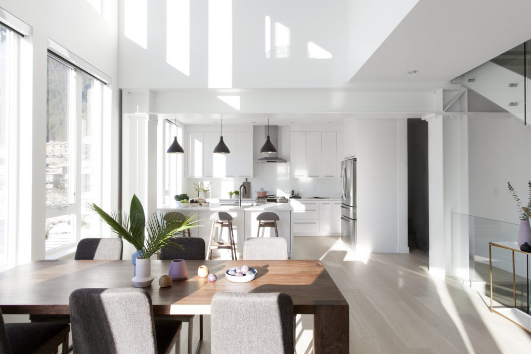 Bright, airy dining and kitchen space with high ceilings and sleek design.