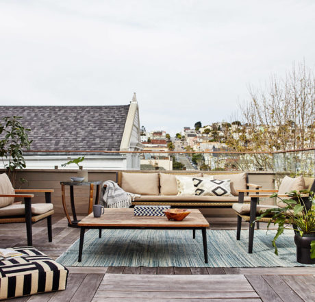 Chic rooftop patio with wooden furniture and urban view