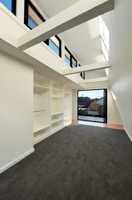 Modern hallway with white walls, skylight, and built-in shelves.