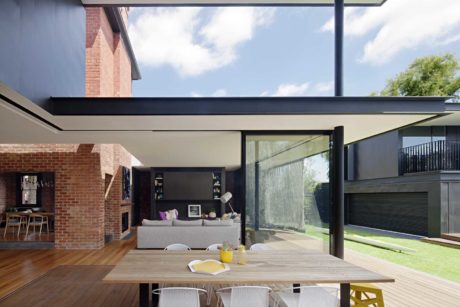 Modern indoor-outdoor living space with large sliding glass doors and wooden deck.