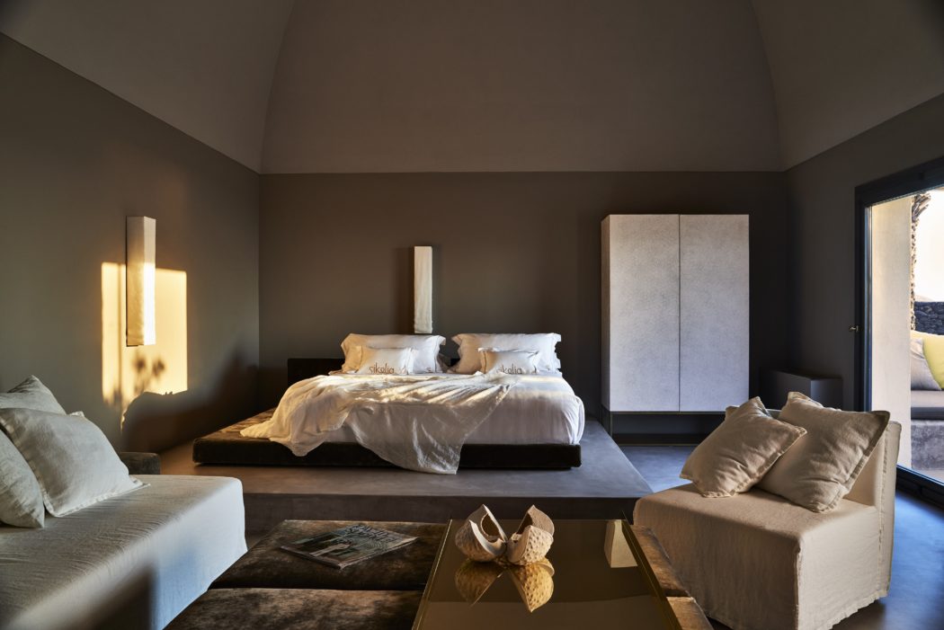 Contemporary bedroom with monochromatic decor and ambient lighting.
