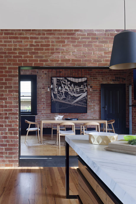 Modern dining room with exposed brick walls and wooden furniture.