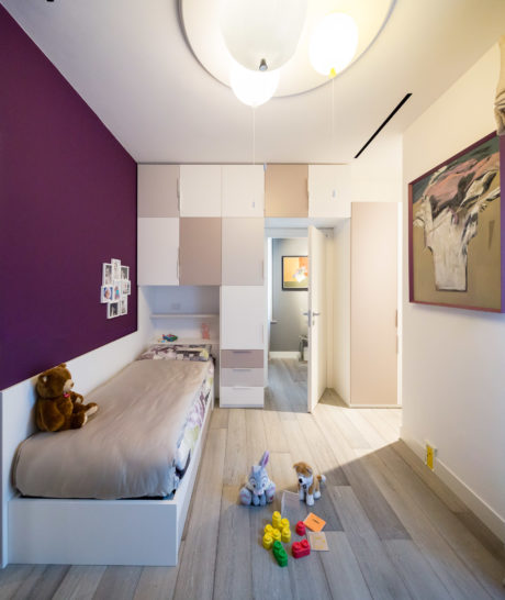 Contemporary child's bedroom with purple accent wall, modular storage, and playful decor