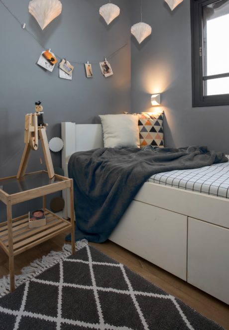 Contemporary bedroom with grey walls and artistic decor.