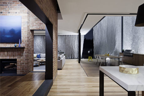 Contemporary open-plan living area with exposed brick and sleek furnishings.
