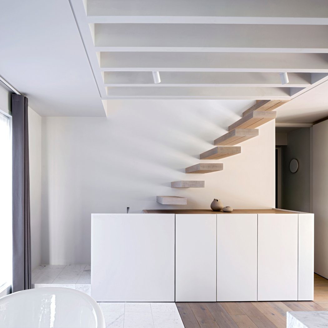 Minimalist interior with floating staircase and clean lines.