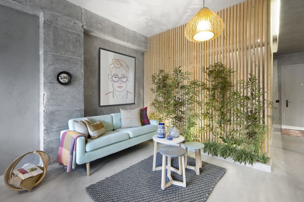 Contemporary living space with slatted wood partition and green plant wall.