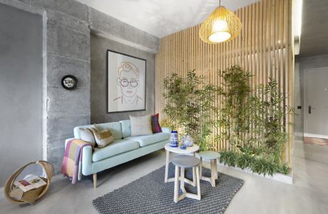 Contemporary living space with slatted wood partition and green plant wall.
