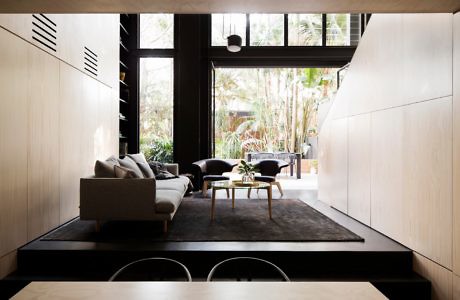 Modern living room with minimalist design, neutral tones, and garden view.