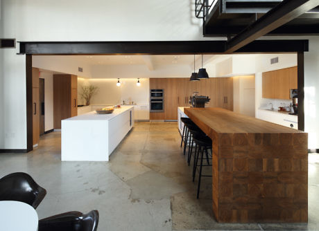 Modern kitchen with wooden cabinets, white countertops, and a large island.