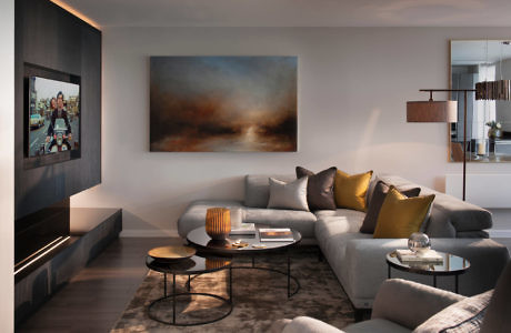 Modern living room with sectional sofa, abstract art, and round coffee tables.