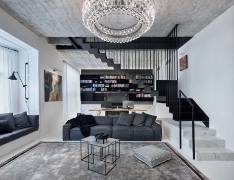 Modern living room with mezzanine, black staircase, and elegant chandelier.