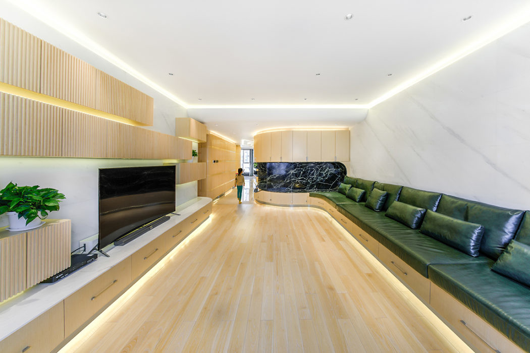 Sleek interior with light wood floors, built-in shelves, and unique long