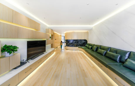 Sleek interior with light wood floors, built-in shelves, and unique long