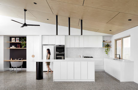 Contemporary kitchen with white cabinetry and wooden ceiling accents.