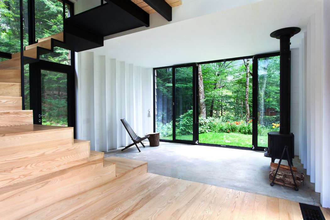 Contemporary interior with wooden staircase, large windows, and minimalist design.