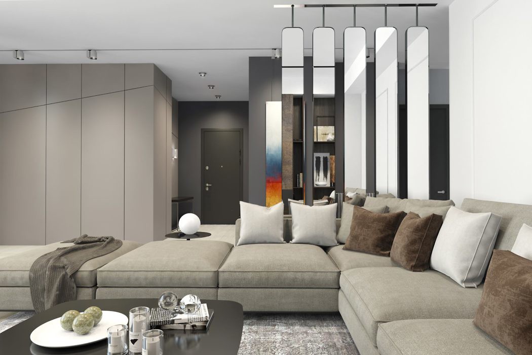Modern living room with gray tones, sectional sofa, and hanging pendant lights.