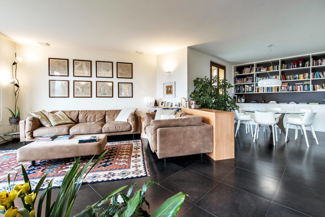 Contemporary living room with plush seating, bookshelf, and dark flooring.