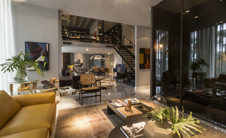 Chic, open-plan living space with a sleek staircase and contemporary furnishings.
