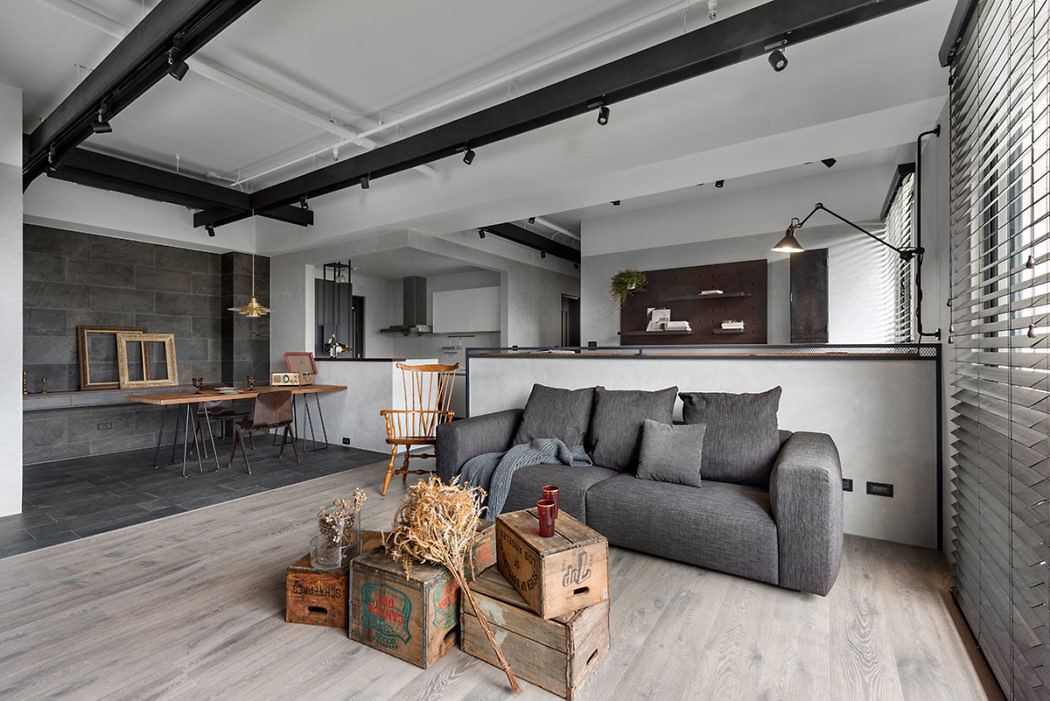 Contemporary loft living space with gray sofa and exposed beams.