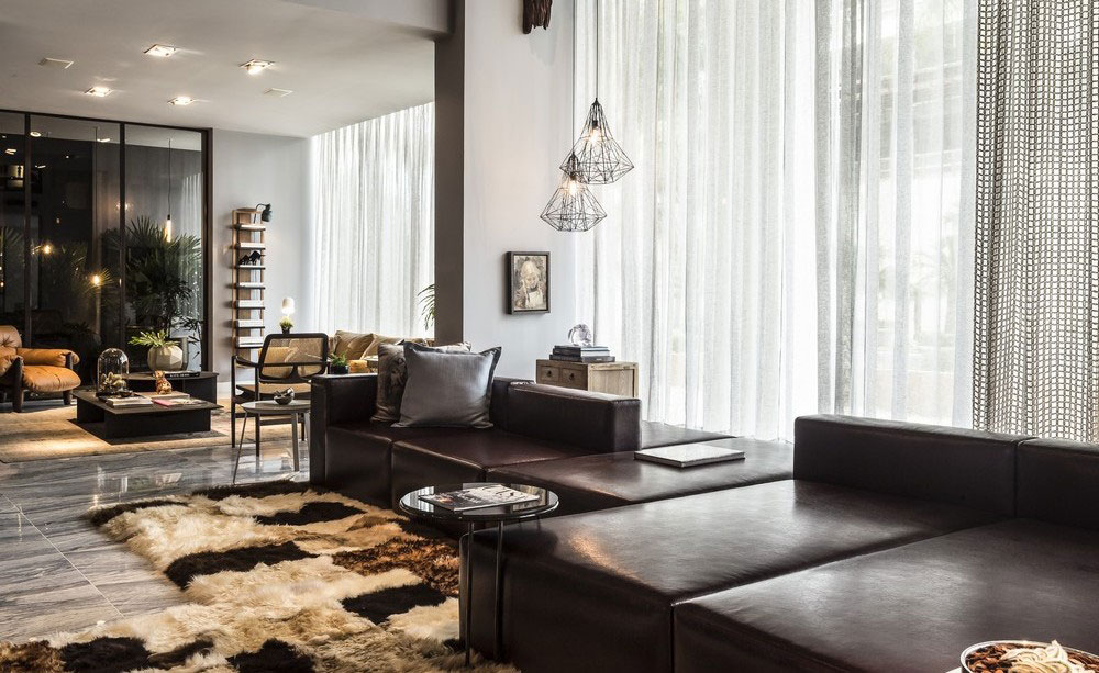 Chic living space with sleek dark furnishings and expansive windows.