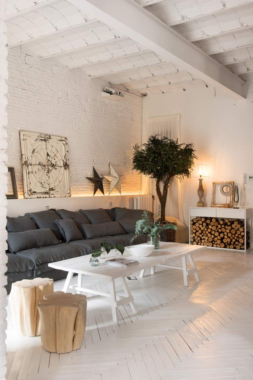 Cozy living room interior with white brick walls and rustic decor.